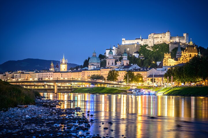 A magical nighttime view of Salzburg’s Old Town and the iconic fortress, reflected in the peaceful waters of the Salzach River. A perfect blend of history and beauty under the night sky.