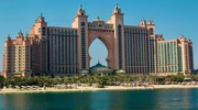 un turn mare cu ceas lângă un corp de apă cu atlantida, palmierul în fundal în emiratele arabe unite
