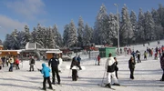 un grup de oameni călărind pe schiuri pe o pârtie acoperită cu zăpadă în borovets