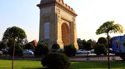 un turn cu ceas în mijlocul unui parc cu india gate în fundal în românia