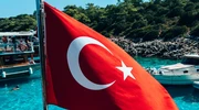 un steag pe spatele unei bărci lângă un corp de apă în turcia