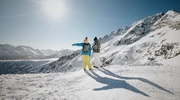 un bărbat călare pe un snowboard pe o pantă acoperită cu zăpadă în bansko