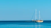 o barcă albastră și albă așezată lângă un corp de apă în turcia