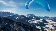 un bărbat care zboară prin aer pe un munte acoperit cu zăpadă în austria