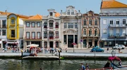 un grup de oameni pe o barcă în fața unei clădiri în portugalia