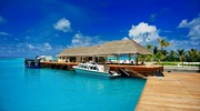 o barcă albastră și albă așezată lângă un corp de apă în maldive
