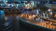 o barcă în apă cu un oraș în fundal în emiratele arabe unite