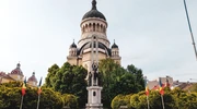 un mic turn cu ceas în fața unei clădiri în românia