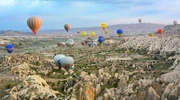 un grup de oameni care zboară zmee pe o stâncă în turcia