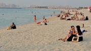 un grup de oameni care stau la o plajă în emiratele arabe unite