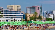 un grup de oameni pe o plajă cu un oraș în fundal în sunny beach