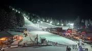 un grup de oameni călărind pe schiuri într-o noapte cu zăpadă în borovets