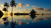 un grup de palmieri cu un apus de soare pe fundal în maldive