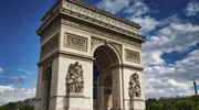 un turn mare cu ceas în fața arcului de triumf în paris
