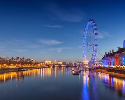 un pod lung peste un corp de apă cu london eye în fundal în londra