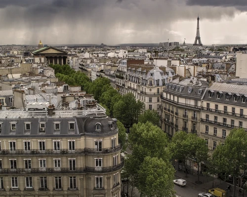 un turn mare cu ceas care se înalță deasupra unui oraș în paris