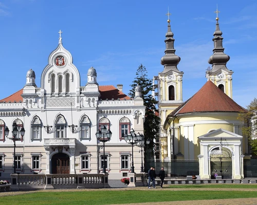 o biserică cu un ceas în fața unei clădiri în timișoara