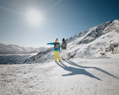 un bărbat călare pe un snowboard pe o pantă acoperită cu zăpadă în bansko