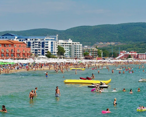 un grup de oameni care înoată într-un corp de apă în sunny beach