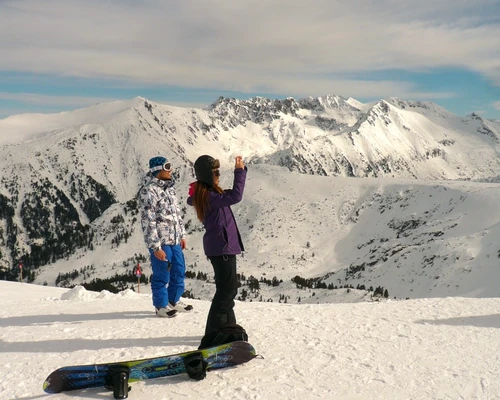 un bărbat călare pe un snowboard pe un munte acoperit cu zăpadă în bansko