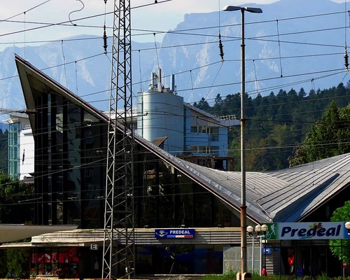 un tren care traversează o stradă în fața unei clădiri în predeal