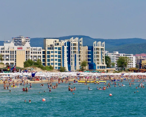 un grup de oameni care înoată într-un corp mare de apă în sunny beach