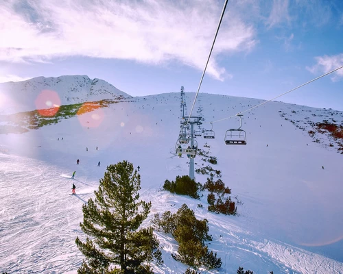 un bărbat care zboară prin aer în timp ce merge pe schiuri în bansko