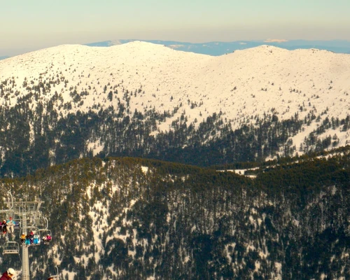 un grup de oameni care stau în vârful unui munte în bansko