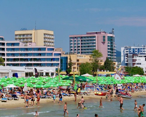 un grup de oameni pe o plajă cu un oraș în fundal în sunny beach